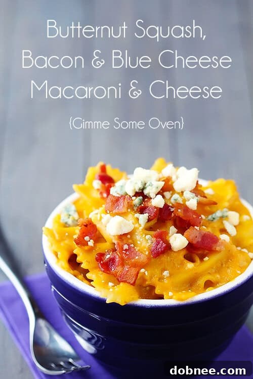 Butternut Squash, Bacon & Blue Cheese Macaroni & Cheese served in a rustic bowl on a wooden surface, with a spoon.