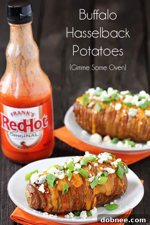 A top-down view of Buffalo Hasselback Potatoes on a blue plate, with a fork, emphasizing the melted cheese and blue cheese crumbles.