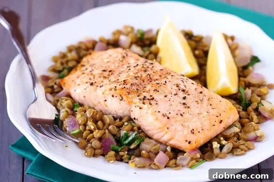 Deliciously baked salmon fillet served over a bed of mildly spiced lentils, garnished with fresh cilantro and lemon wedges. A healthy and easy weeknight meal.