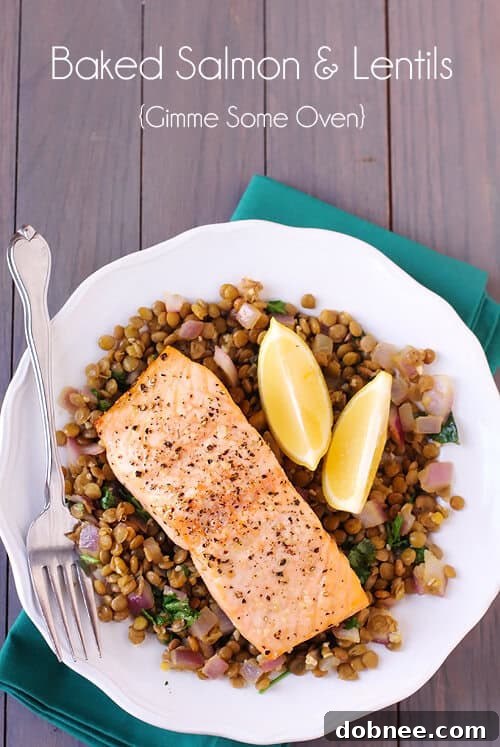 Close-up of baked salmon and lentils, showcasing the flaky texture of the fish and the vibrant spices in the lentil bed.