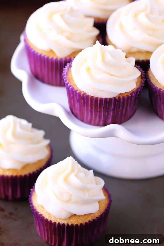 Close-up of a frosted vanilla cupcake, showcasing the smooth vanilla buttercream and delicate crumb texture.