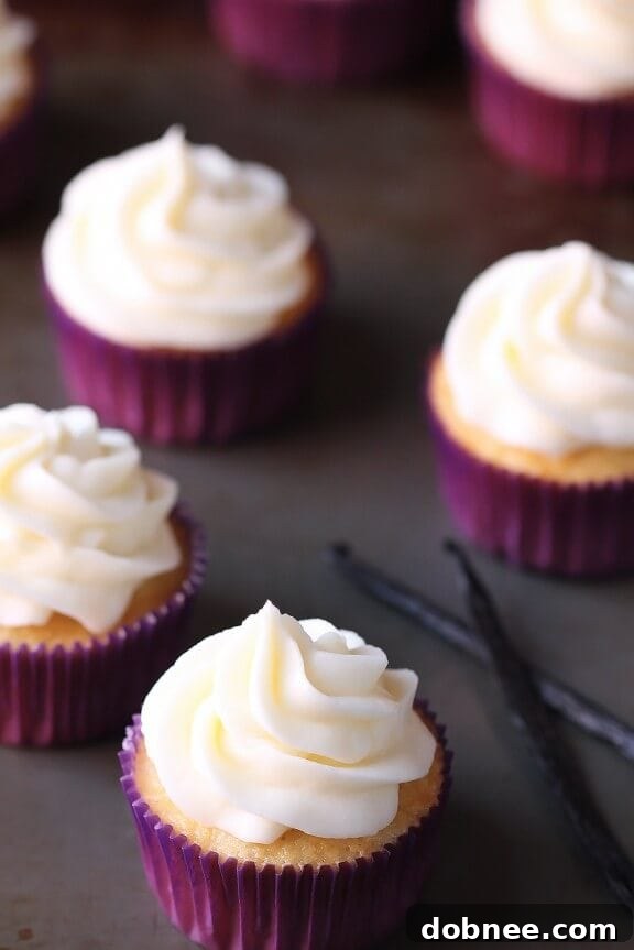 A close-up of a vanilla cupcake on a cooling rack, showing its golden-brown exterior and fluffy texture before frosting.