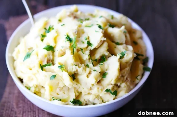 Creamy Hummus Mashed Potatoes served in a bowl, garnished with fresh parsley and a drizzle of olive oil. A delicious vegan and vegetarian side dish.