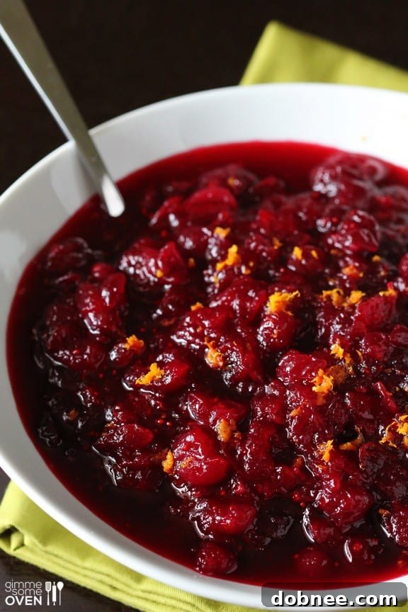 Close-up shot of homemade Orange Bourbon Cranberry Sauce with visible orange zest and cranberries, ready to be served.