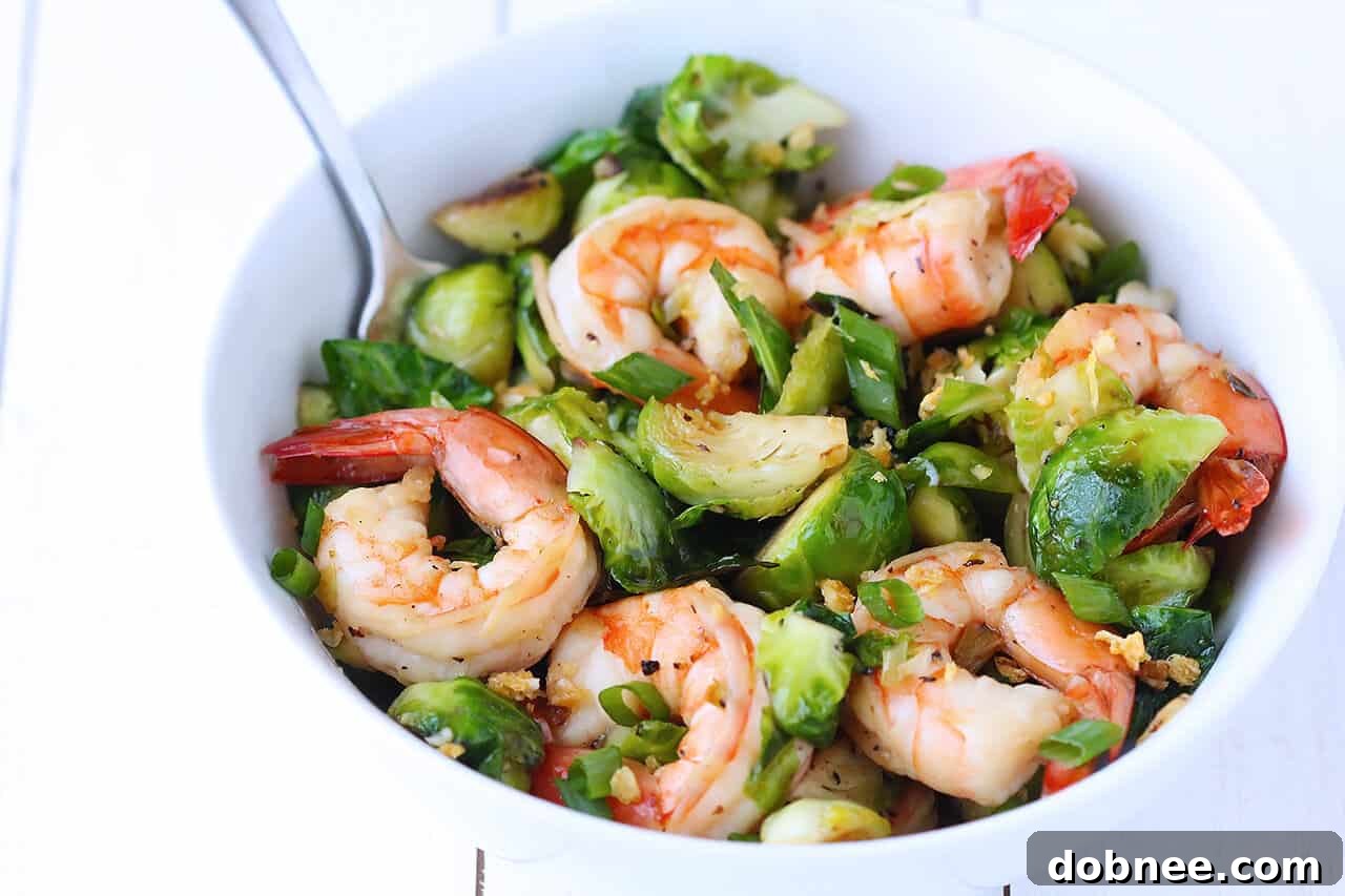 A close-up of the Honey Sesame Shrimp and Brussels Sprouts Stir Fry, emphasizing the caramelized sprouts and glossy shrimp.