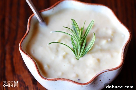 Creamy Potato Pear Soup served in a rustic bowl, garnished with fresh rosemary