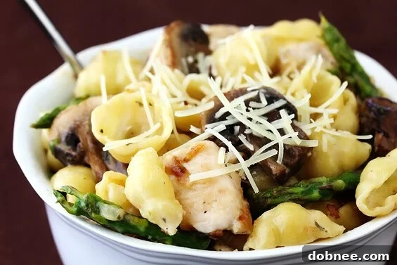 Creamy pasta dish featuring tender goat cheese sauce, fresh asparagus, mushrooms, and optional chicken.