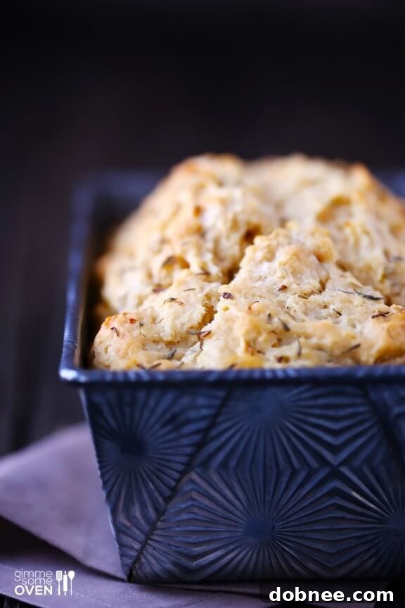 Sliced Whole Wheat Garlic & Herb Beer Bread on a cutting board, showing its moist interior.