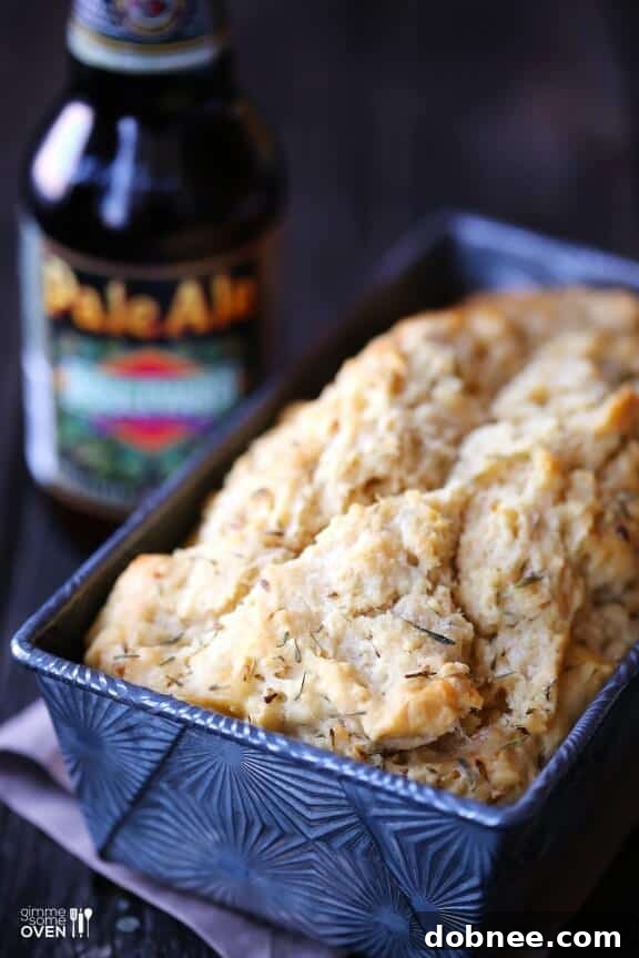 A top-down view of the rustic, golden-brown crust of the Whole Wheat Garlic & Herb Beer Bread.