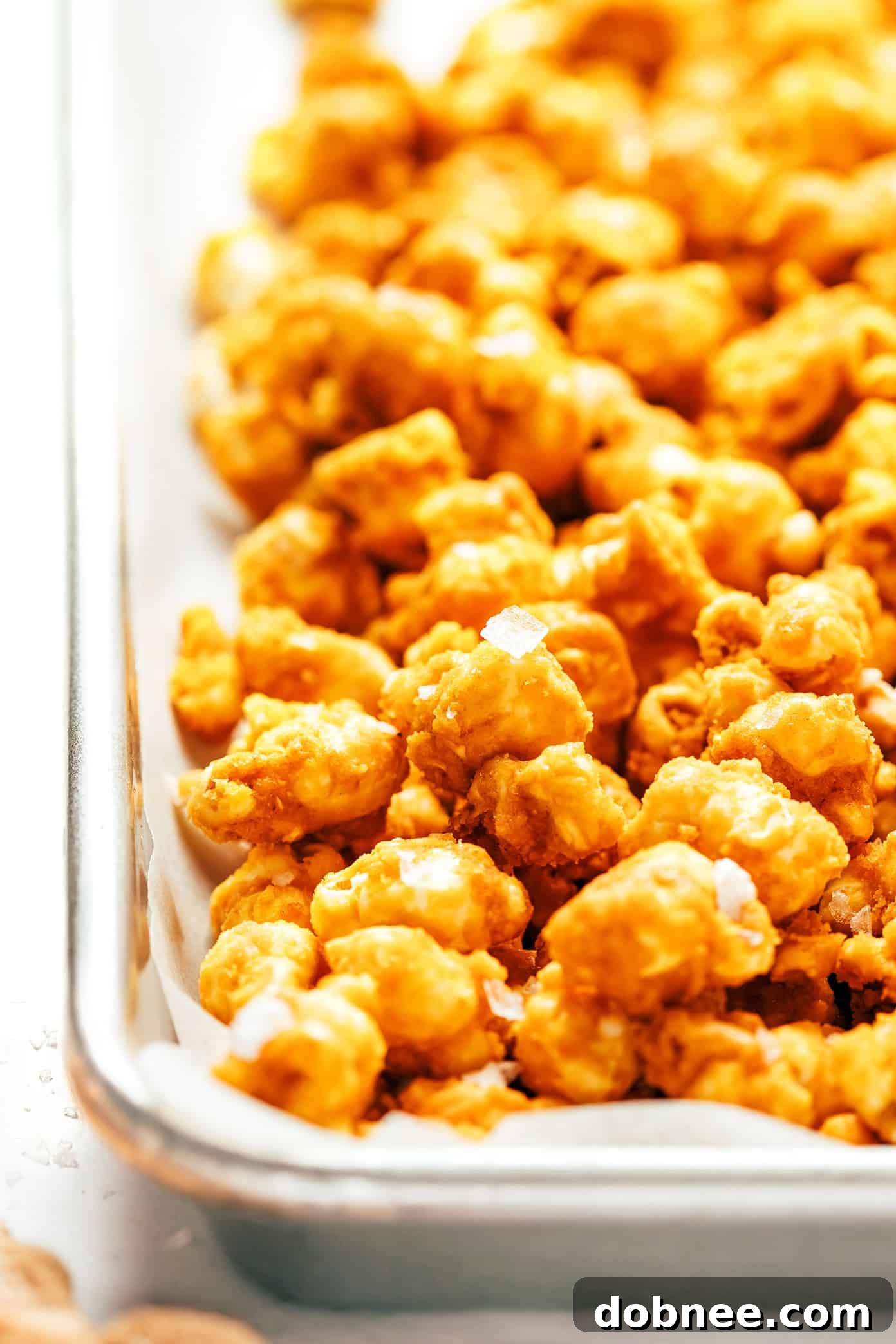Caramel corn cooling on parchment paper after baking.