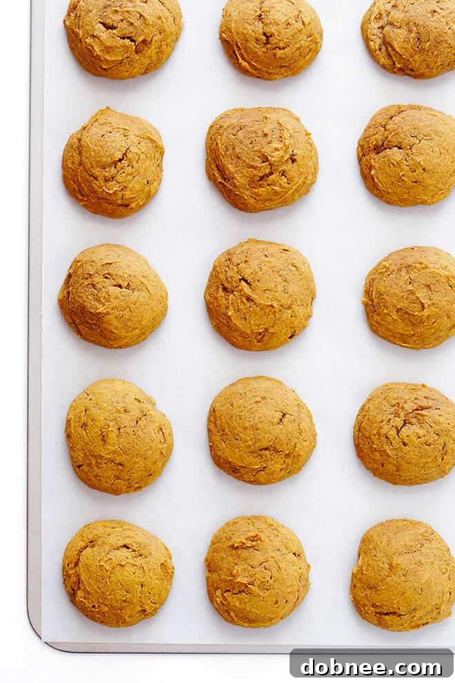 Preparing the soft pumpkin cookie dough on a parchment-lined baking sheet, ready for the oven.