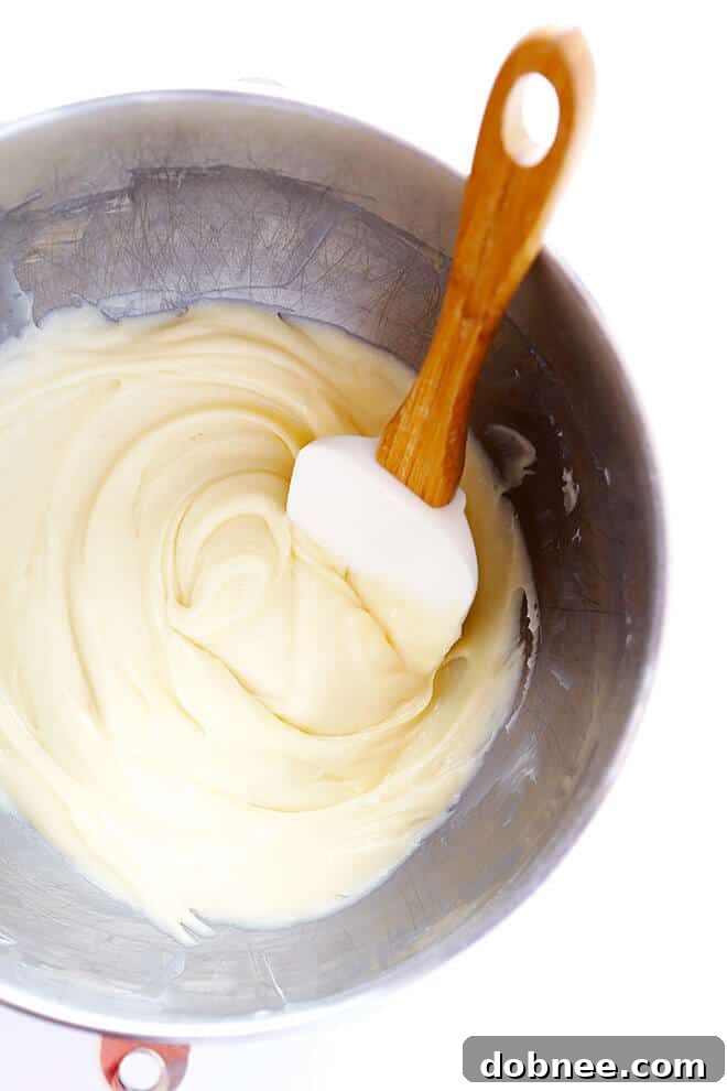 Pumpkin cookie dough carefully scooped and lightly flattened on a parchment-lined baking sheet, prepared for baking.