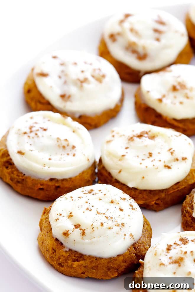 Soft pumpkin cookies freshly frosted with a generous layer of cream cheese frosting and a sprinkle of pumpkin pie spice.
