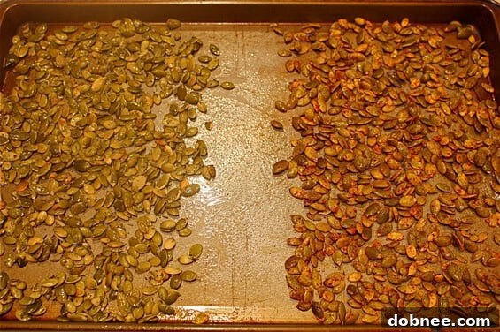 Two bowls of roasted pumpkin seeds with different seasonings, chili-lime-cumin and herbs de provence.