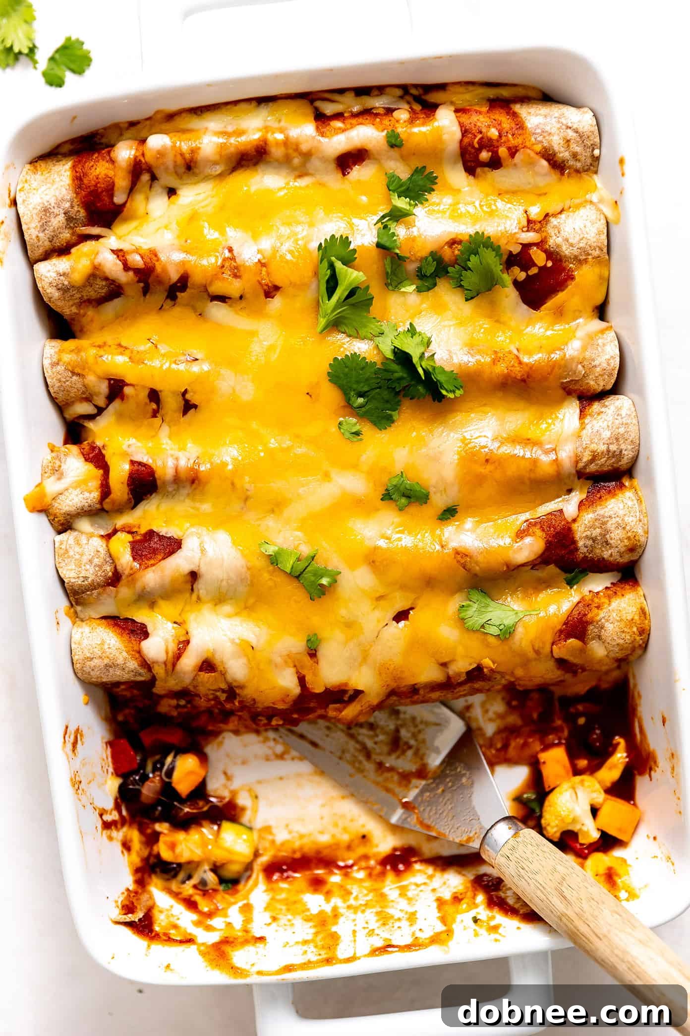 This Tex-Mex-inspired roasted vegetable enchiladas recipe is easy to customize with your choice of veggies, beans, cheese. Always a delicious vegetarian dinner recipe! | gimmesomeoven.com Roasted Vegetable Enchiladas in the baking pan, fresh from the oven