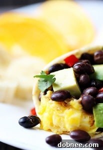 Stacked breakfast burritos with black beans and avocado