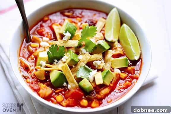 A vibrant bowl of Chipotle Chicken and Rice Soup garnished with fresh avocado and cilantro