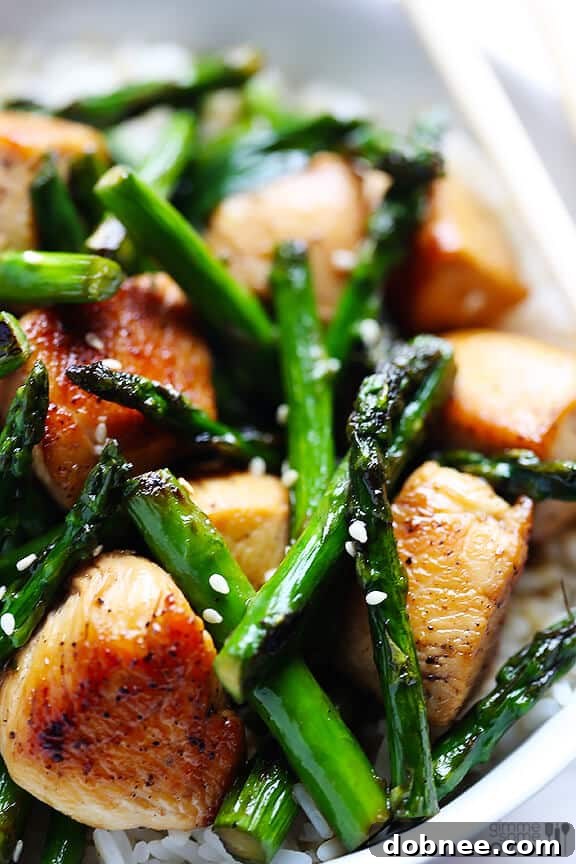 Close-up of chicken and asparagus cooking with sauce