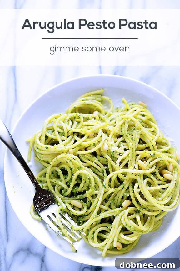 Food processor blending arugula pesto ingredients