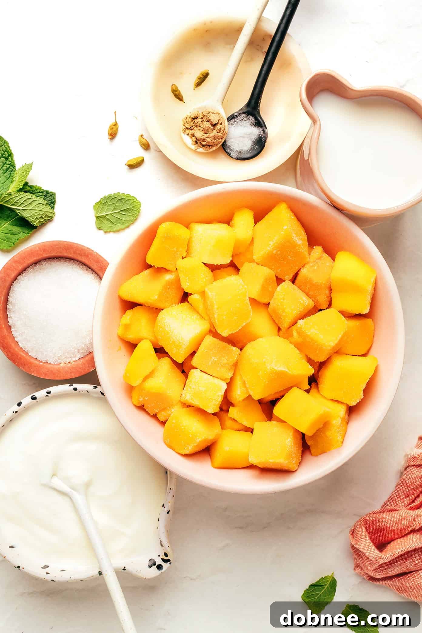 Freshly blended mango lassi being poured into a tall glass