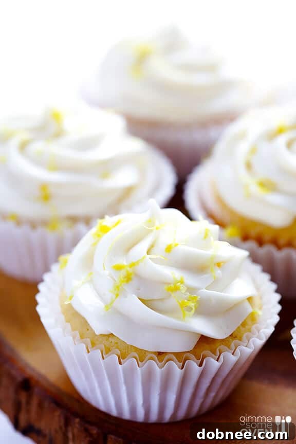Close-up of a Honey Lemon Cupcake with Honey Cream Cheese Frosting, garnished with lemon zest.