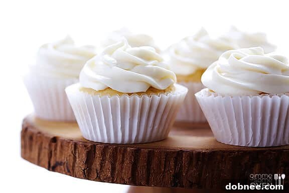 A close-up shot of a Honey Lemon Cupcake, showcasing its fluffy frosting and vibrant lemon zest.