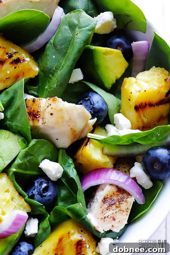 Vibrant and colorful Grilled Pineapple, Chicken & Avocado Salad with blueberries and feta