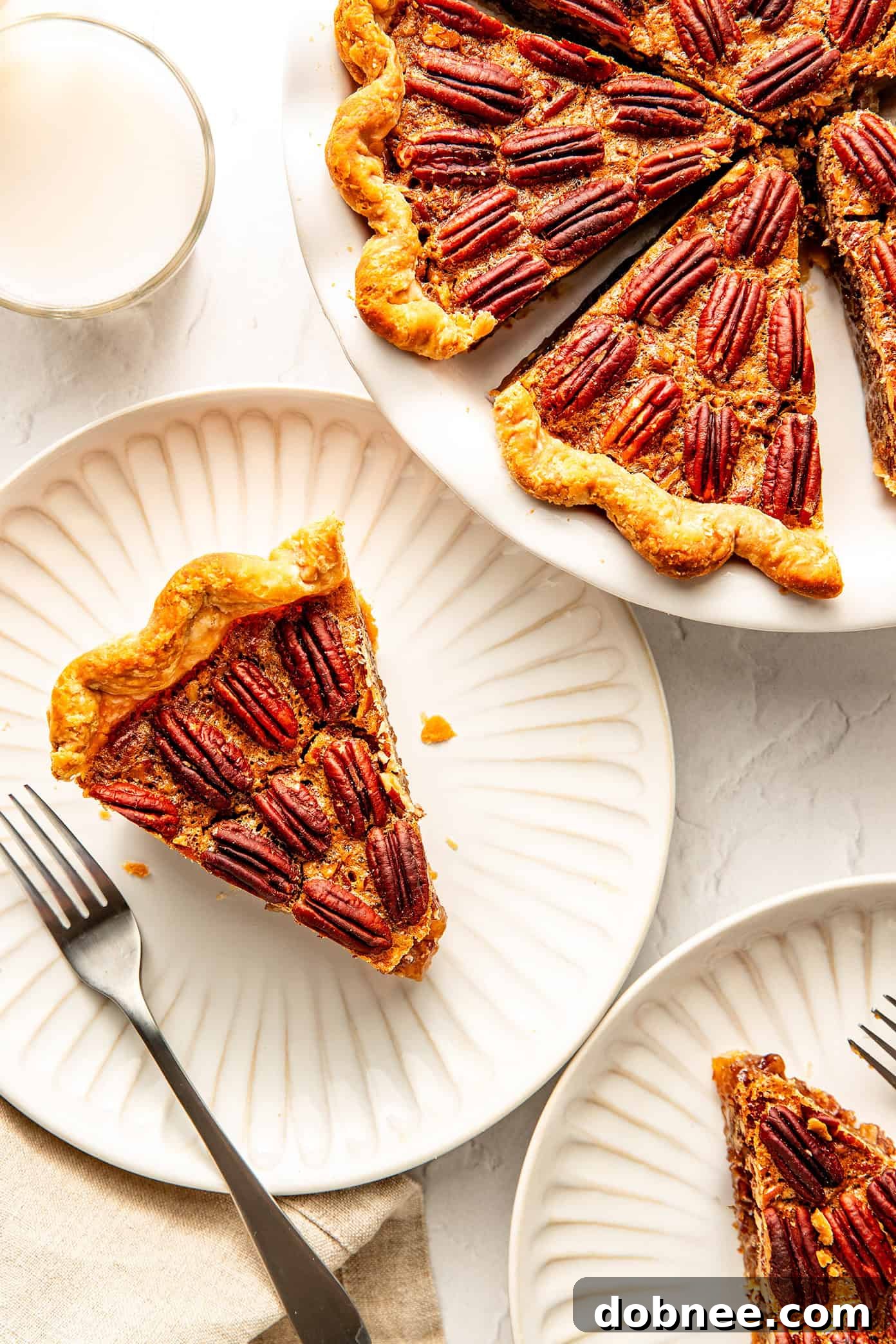 A delicious pecan pie slice served with a dollop of whipped cream.