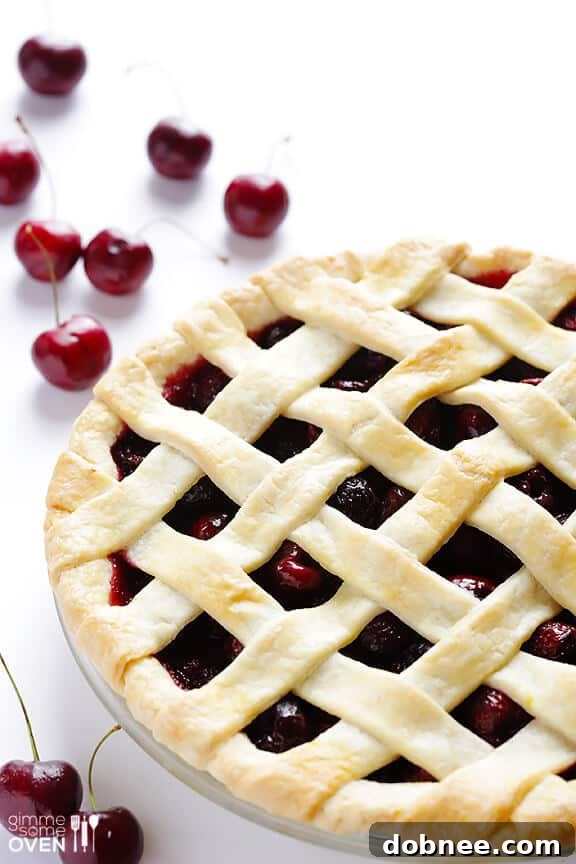 Close-up of a freshly baked sweet cherry pie, highlighting its vibrant red filling and golden brown crust