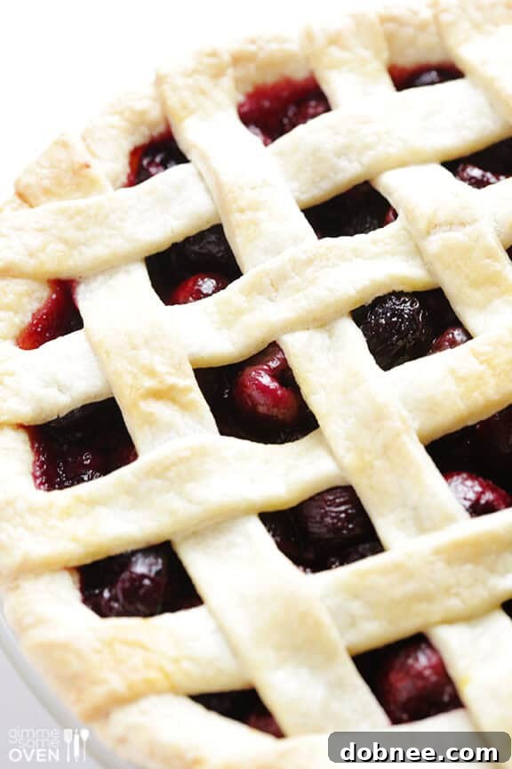 A sweet cherry pie with a golden lattice crust, perfectly baked and cooling on a wire rack