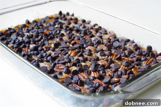 Close-up of baked English Toffee Bars in a pan, showing the layers of crust, toffee, pecans, and chocolate