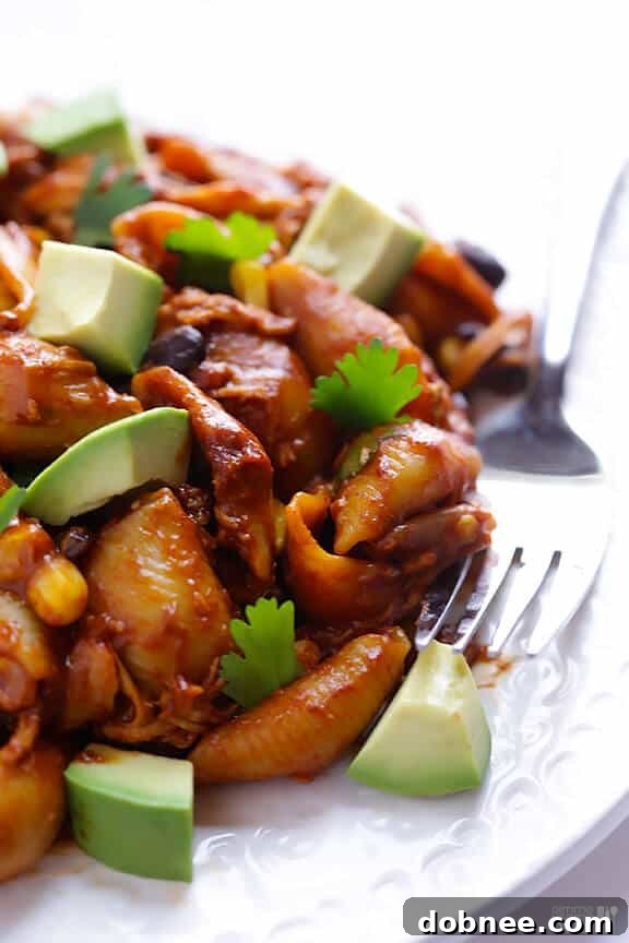 Close-up of Chicken Enchilada Pasta Bake with melted cheese and fresh cilantro garnish