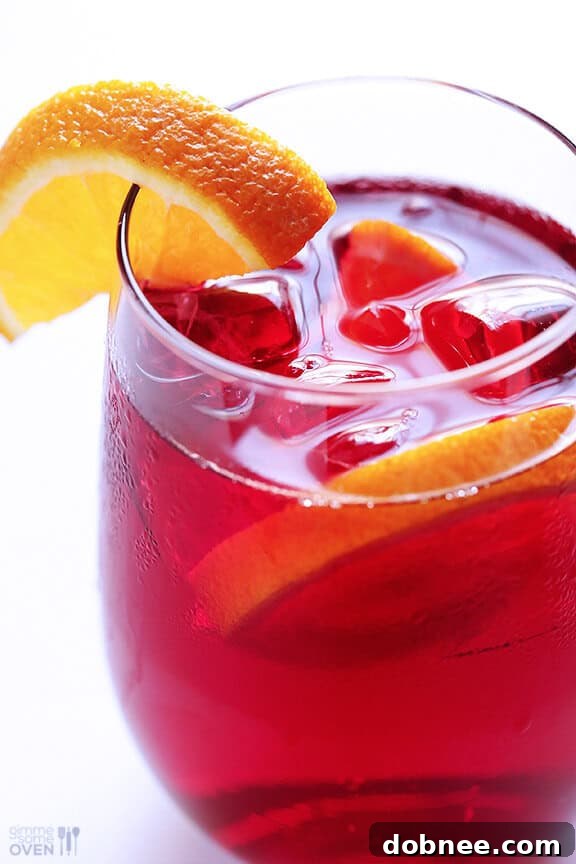 A glass of refreshing Agua de Jamaica (Hibiscus Tea) with lime slices.