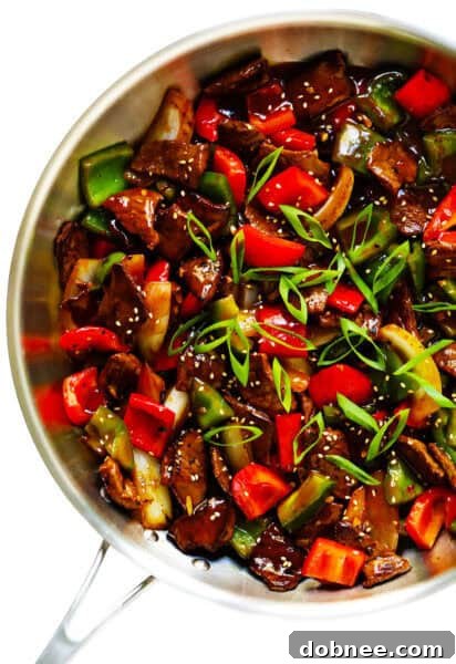 Easy Pepper Steak served over white rice, garnished with green onions.
