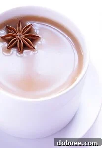 Homemade Chai Tea Concentrate in a bottle, with a finished chai latte in a mug beside it, showcasing the final product.