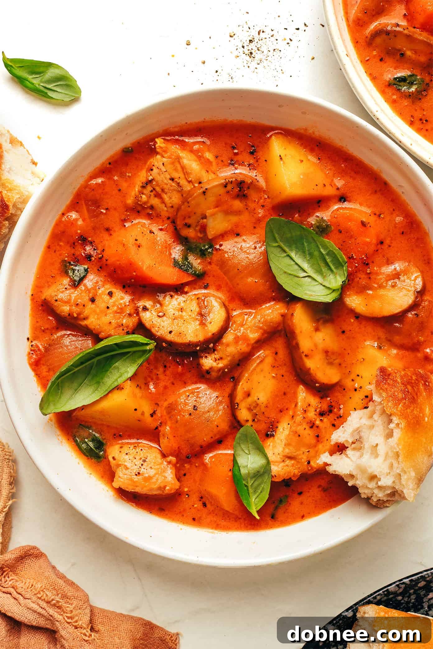 Mediterranean Chicken Tomato Basil Stew 7 A bowl of delicious tomato basil chicken stew with crusty bread for dipping