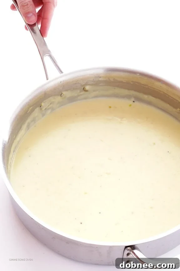 Closeup of skinny fettuccine alfredo with parsley garnish, showcasing its creamy texture.