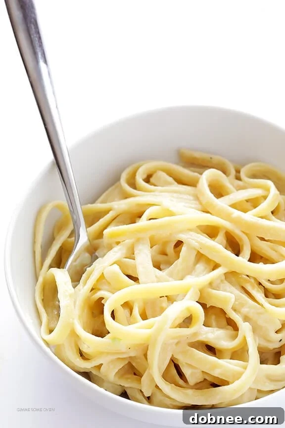 A bowl of skinny fettuccine alfredo garnished with fresh parsley.