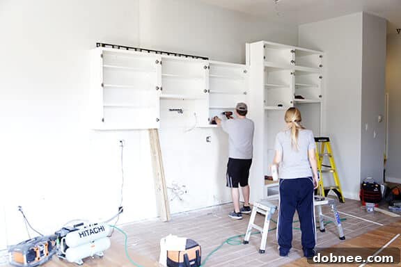 Kitchen space with new wiring and plumbing before cabinet installation.