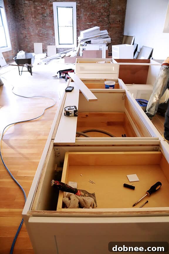 Stack of flat-pack cabinet boxes in kitchen remodel.