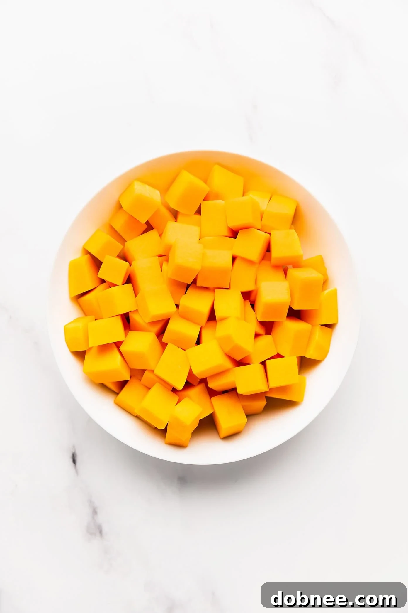 Fresh butternut squash on a wooden table, ready for prep