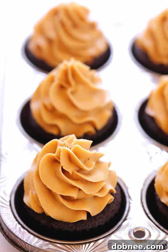 Close-up of a Chocolate Peanut Butter Cupcake with a bite taken, revealing the Reese's inside