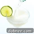 Sparkling Margarita in a champagne flute with a lime slice and salted rim.