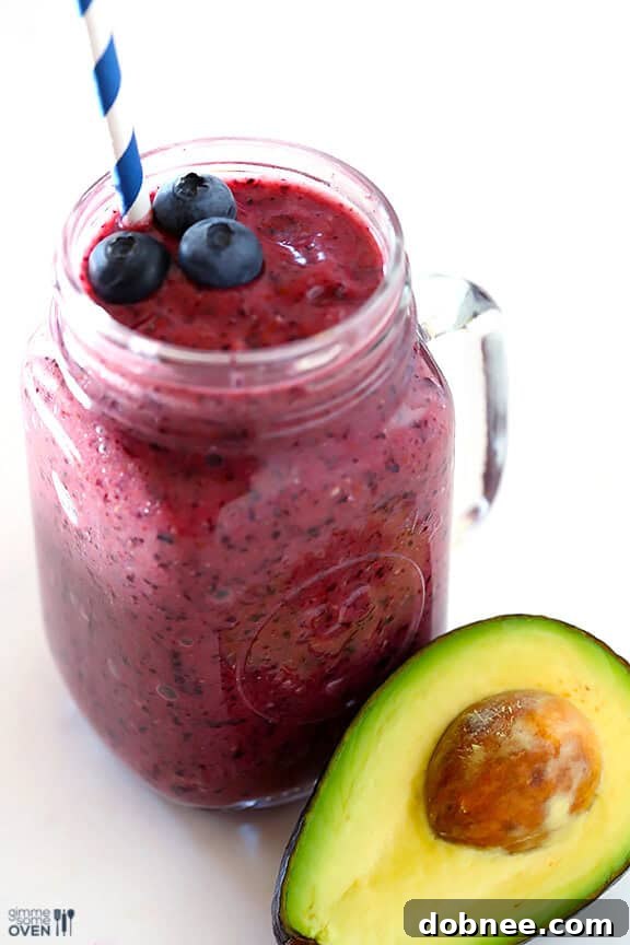 Pouring the freshly blended Brain Power Blueberry Avocado Smoothie into a glass, ready to be enjoyed.
