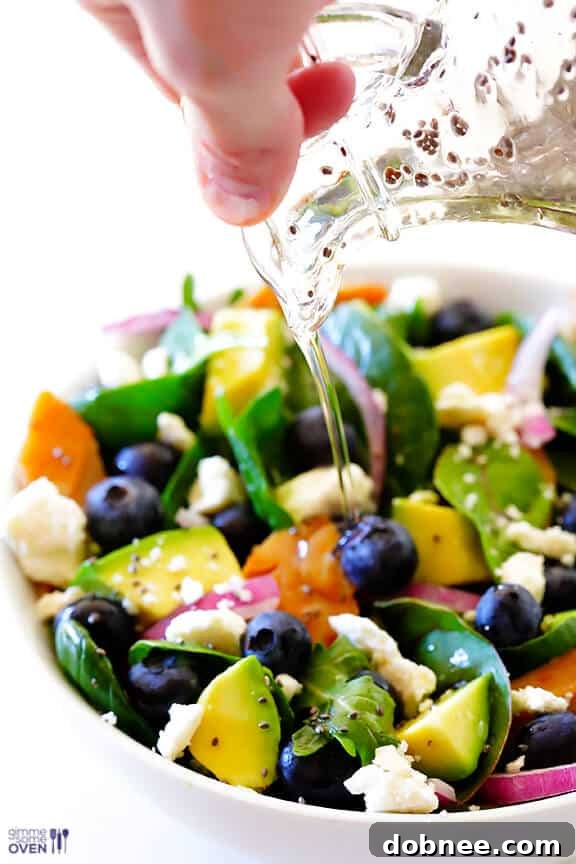 Arrangement of Brain Power Salad ingredients: salmon, avocado, blueberries, walnuts, and greens.