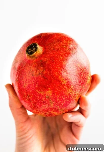 Pomegranate being prepared for de-seeding, showing knife and bowl of water