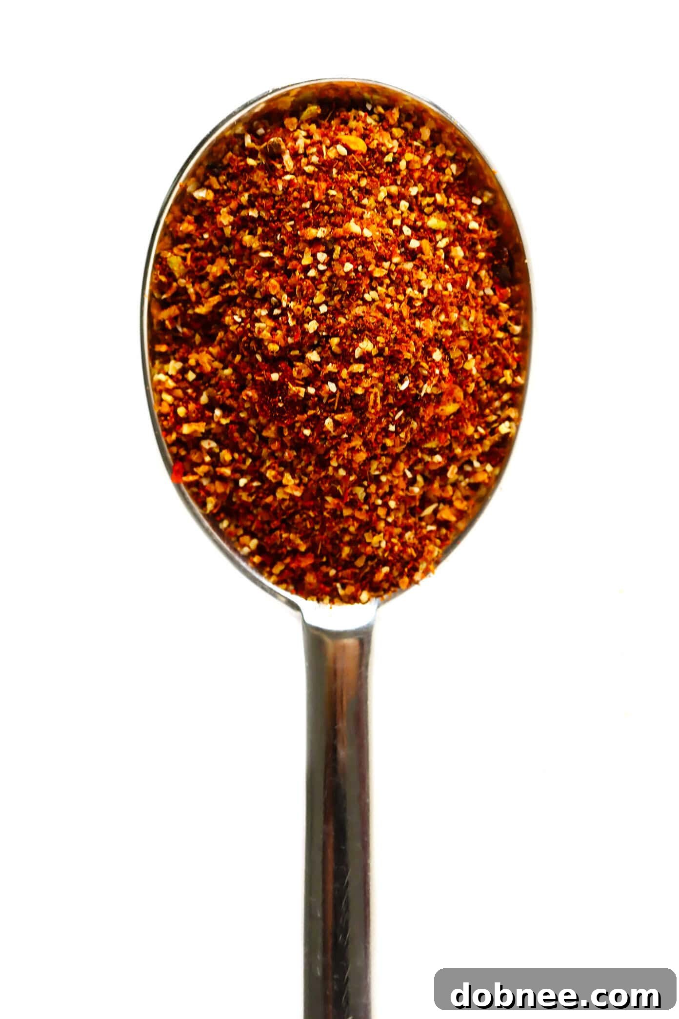 A bowl of freshly prepared homemade taco seasoning, ready for use, with some spices scattered around