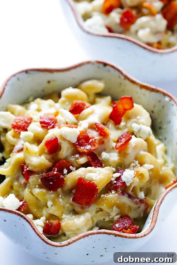 A serving of Blue Cheese Bacon Macaroni and Cheese with a fork, emphasizing its creamy texture.