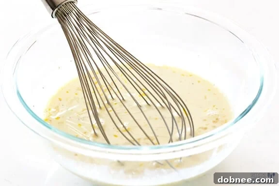 Whisking evaporated milk and eggs for the creamy mac and cheese sauce.