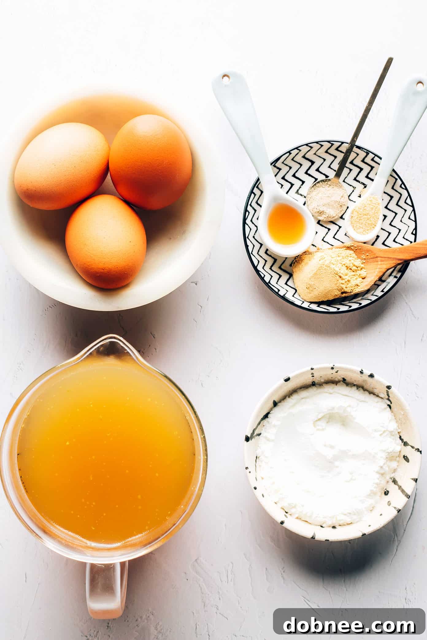 Close-up of golden egg ribbons swirling in clear broth, garnished with green onions.